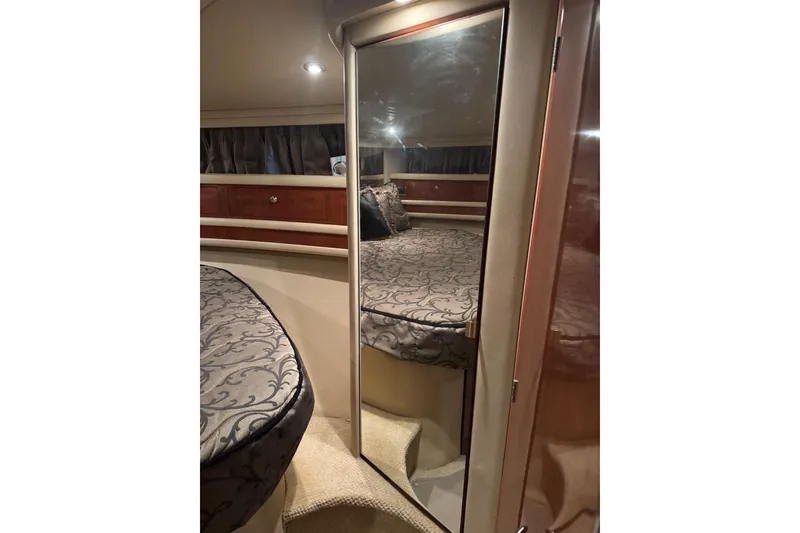 Slide: The Image of 2003 Sea Ray 480 Sedan Bridge cabin interior with elegant bedding and mirrored closet. - 20