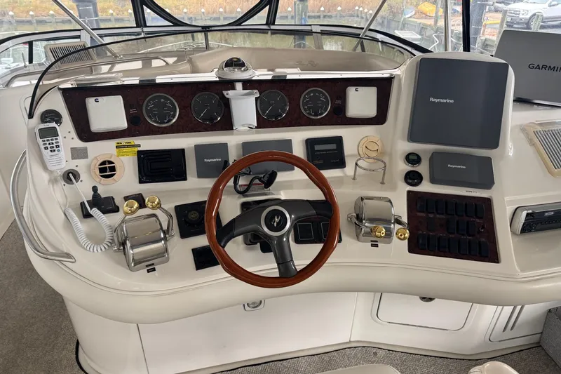 Slide: The Image of 2003 Sea Ray 480 Sedan Bridge helm with steering wheel, gauges, and navigation equipment. - 26