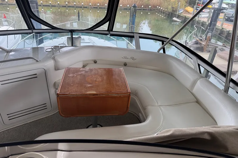 Slide: The Image of Luxurious 2003 Sea Ray 480 Sedan Bridge interior with white seating and wooden table. - 35