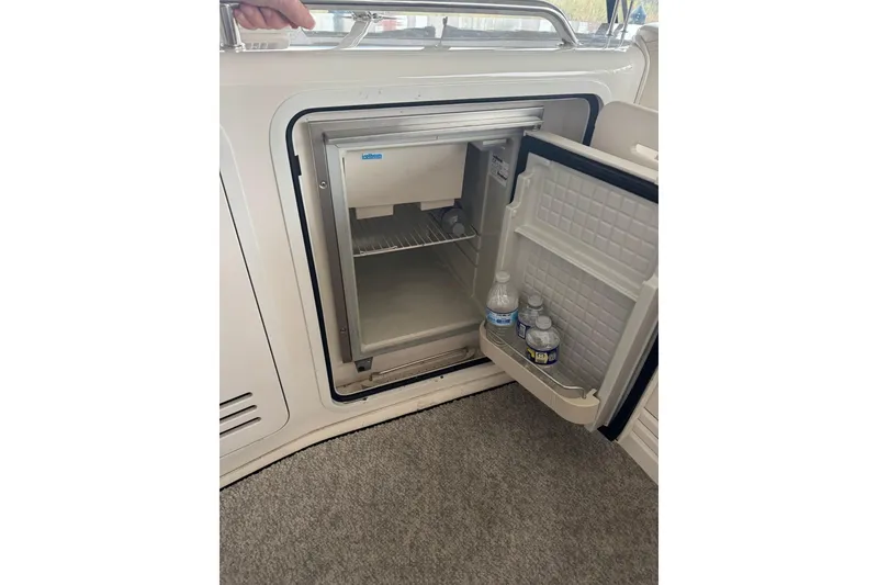 Slide: The Image of Open mini fridge on 2003 Sea Ray 480 Sedan Bridge with water bottles inside. - 39