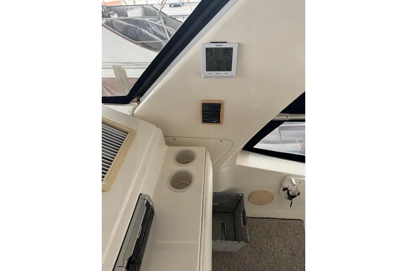 Slide: The Image of Interior of 2003 Sea Ray 480 Sedan Bridge yacht with control panel and cup holders. - 40