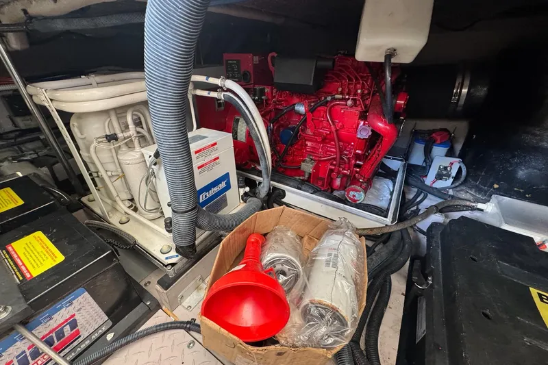 Slide: The Image of Engine room of 2003 Sea Ray 480 Sedan Bridge with red engine and maintenance tools. - 42