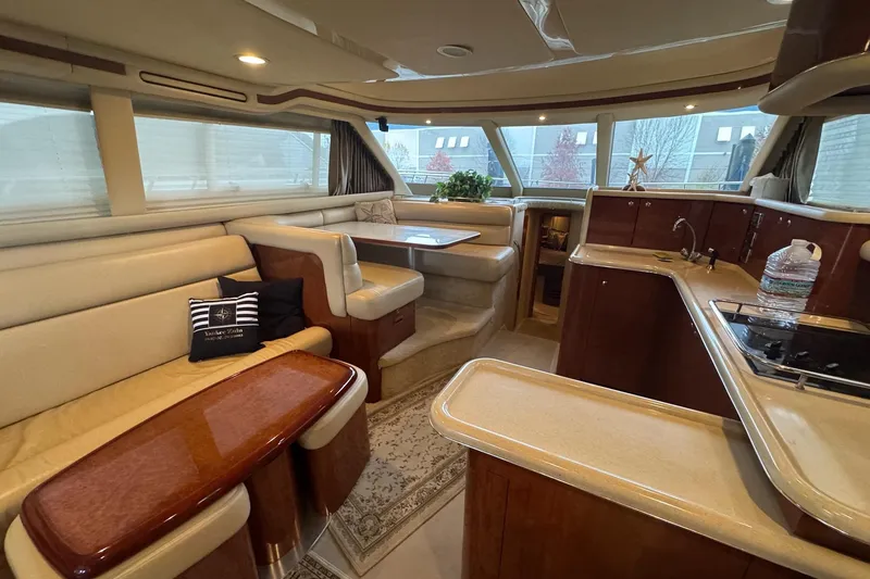 Slide: The Image of Luxurious interior of 2003 Sea Ray 480 Sedan Bridge yacht with elegant seating and kitchen area. - 5