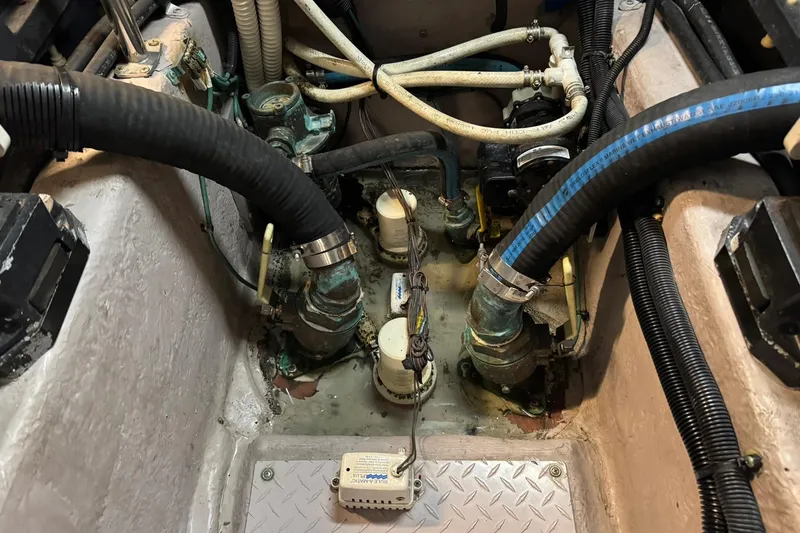 Slide: The Image of Engine compartment of a 2003 Sea Ray 480 Sedan Bridge with visible hoses and fittings. - 50