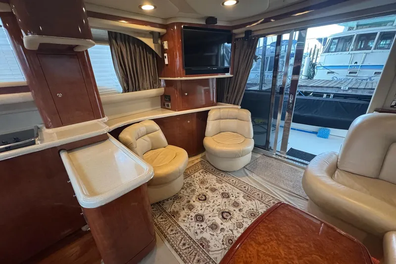 Slide: The Image of Luxurious 2003 Sea Ray 480 Sedan Bridge interior with plush seating and elegant wood finishes. - 8