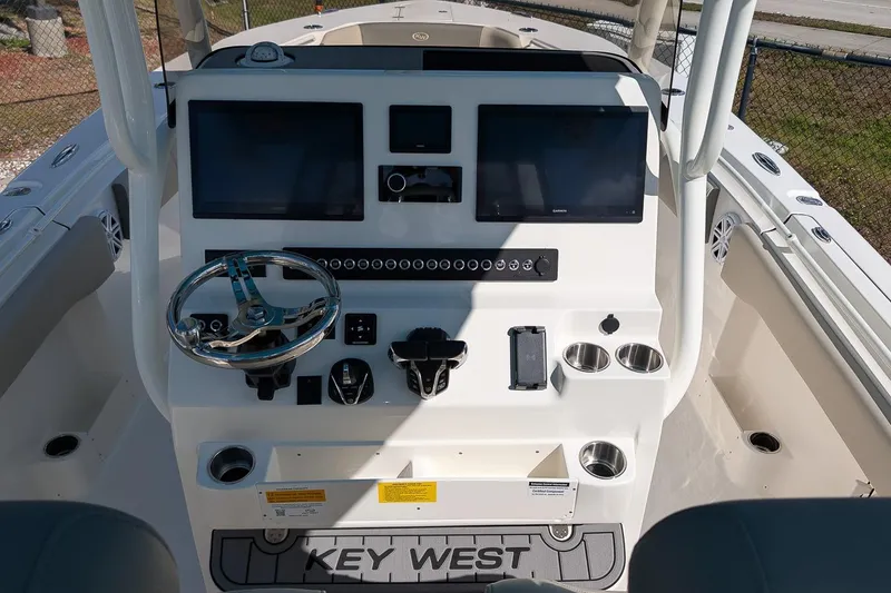 Slide: The Image of 2026 Key West 291 FS boat dashboard with dual screens and steering wheel. - 14