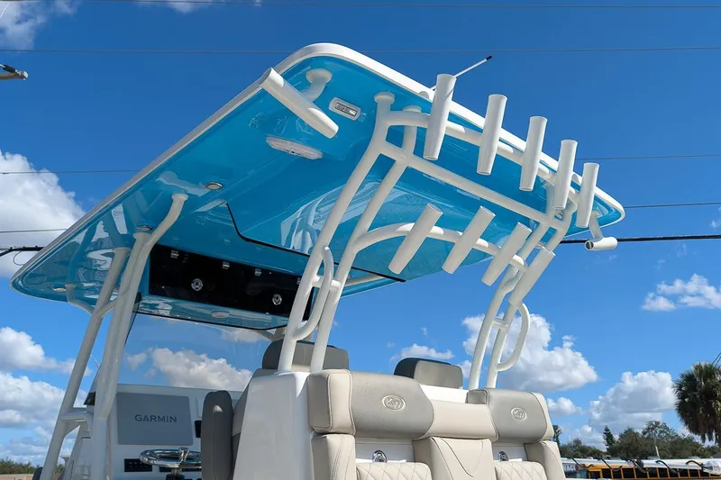 Slide: The Image of 2026 Key West 291 FS boat with blue T-top and rod holders under clear sky. - 22