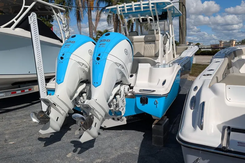Slide: The Image of 2026 Key West 291 FS boat with dual outboard engines, docked under a sunny sky. - 3