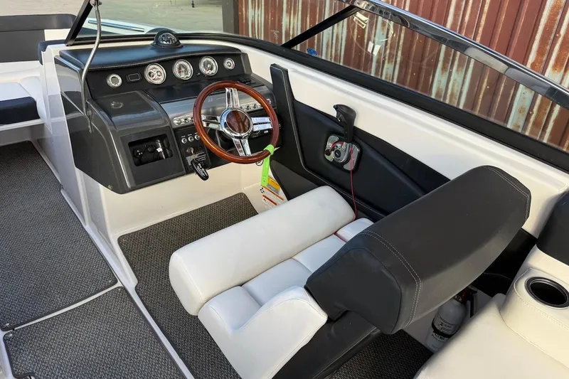 Slide: The Image of 2014 Four Winns SL242 boat interior with steering wheel and dashboard controls. - 10