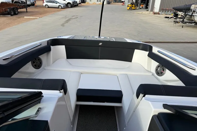 Slide: The Image of 2014 Four Winns SL242 boat interior with black and white seating, docked outdoors. - 14