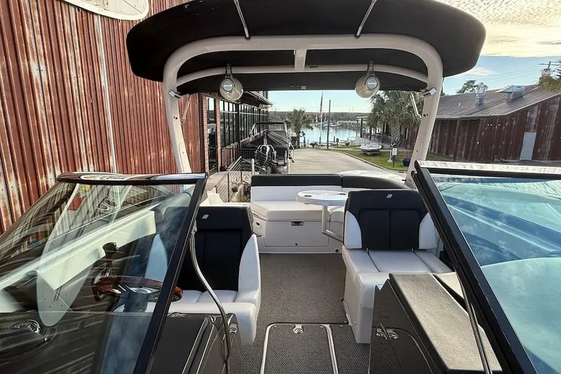 Slide: The Image of 2014 Four Winns SL242 boat interior with seating, dockside view, and waterfront background. - 17