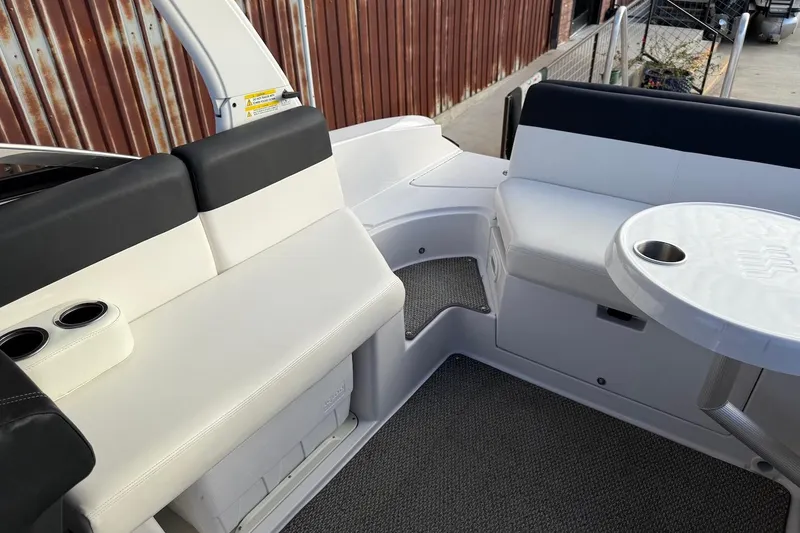 Slide: The Image of 2014 Four Winns SL242 boat interior with seating and table, featuring cup holders. - 18