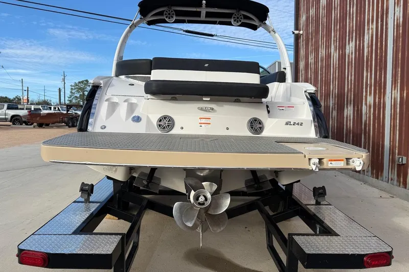 Slide: The Image of 2014 Four Winns SL242 boat on trailer, rear view with propeller and swim platform. - 3