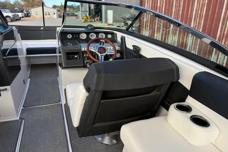 Slide: The Image of 2014 Four Winns SL242 boat interior with steering wheel and seating area. - 8