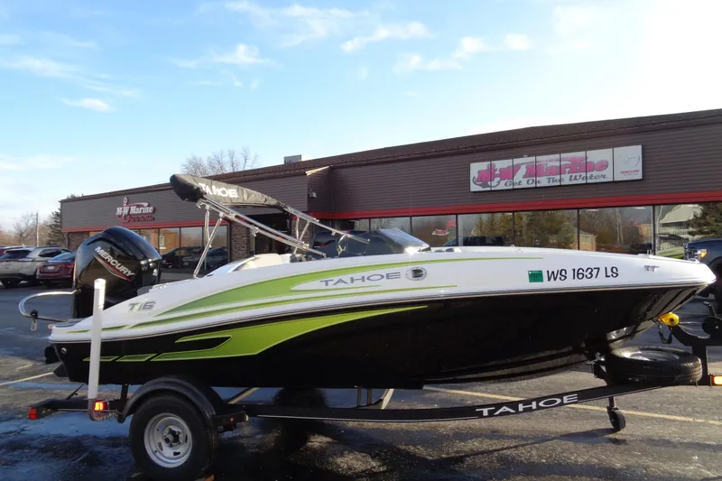 The Image of 2023 Tahoe T16 boat on trailer outside dealership, featuring sleek design and Mercury engine. - 0