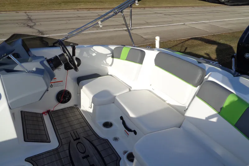 Slide: The Image of 2023 Tahoe T16 boat interior with gray and green seating, steering wheel, and deck. - 13