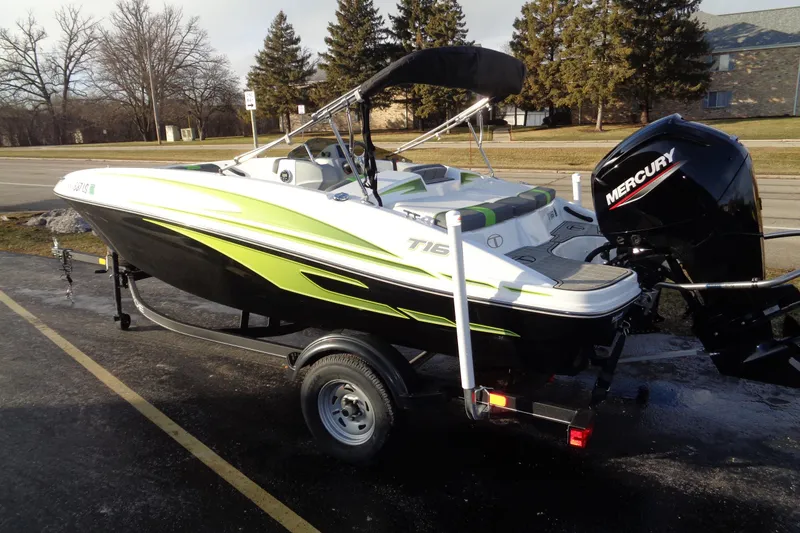 Slide: The Image of 2023 Tahoe T16 boat with Mercury engine on trailer, parked outdoors. - 2