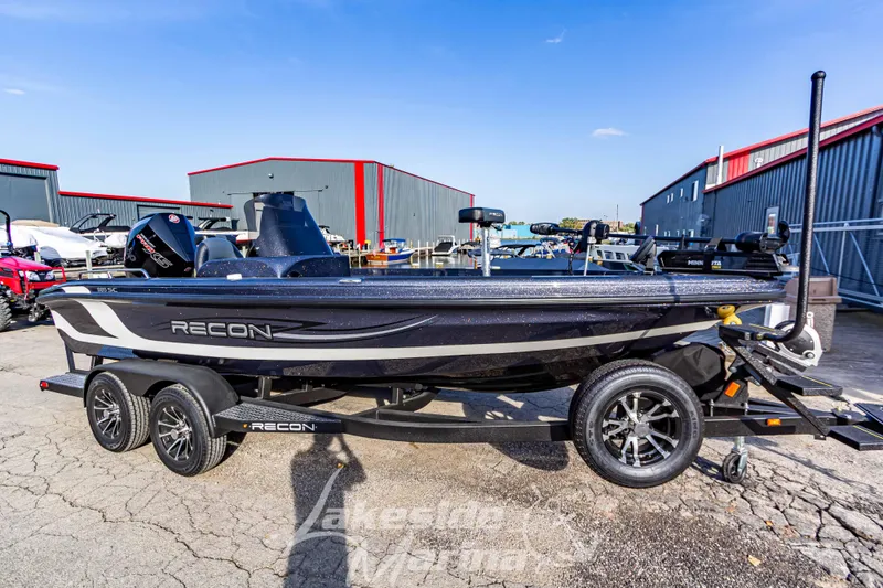 The Image of 2024 Recon 985 SC fishing boat on a trailer in a marina. - 1