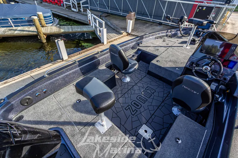 Slide: The Image of 2024 Recon 985 SC fishing boat at dock, featuring spacious deck and modern seating. - 11