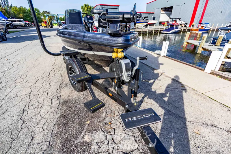 Slide: The Image of 2024 Recon 985 SC boat on trailer near marina. - 9