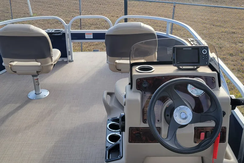 Slide: The Image of 2021 Sun Tracker Bass Buggy 16 XL Select pontoon boat interior with steering console and seating. - 8
