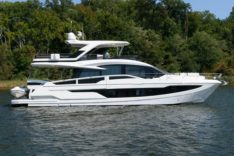 The Image of 2018 Galeon 640 Fly yacht cruising on a serene river with lush green trees. - 0