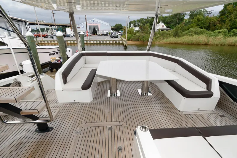 Slide: The Image of Galeon 640 Fly 2018 yacht deck with bar stools overlooking serene water. - 20