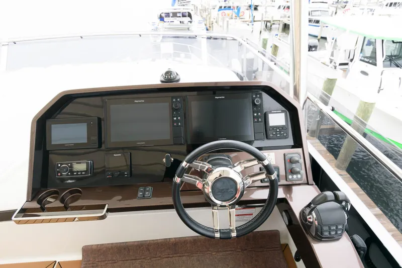 Slide: The Image of Spacious deck of 2018 Galeon 640 Fly yacht with seating and table, overlooking serene waterway. - 27