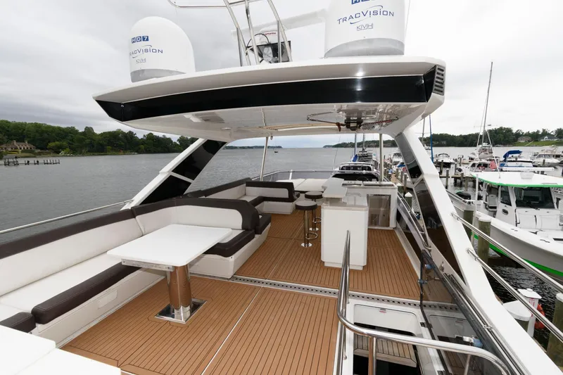 Slide: The Image of 2018 Galeon 640 Fly yacht helm with plush seating at marina. - 29