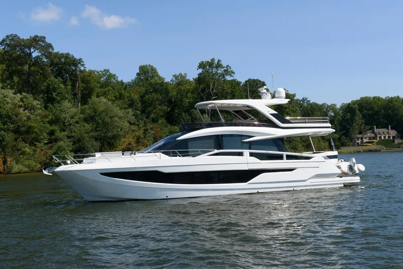 Slide: The Image of 2018 Galeon 640 Fly yacht cruising on a serene lake with lush green trees. - 3