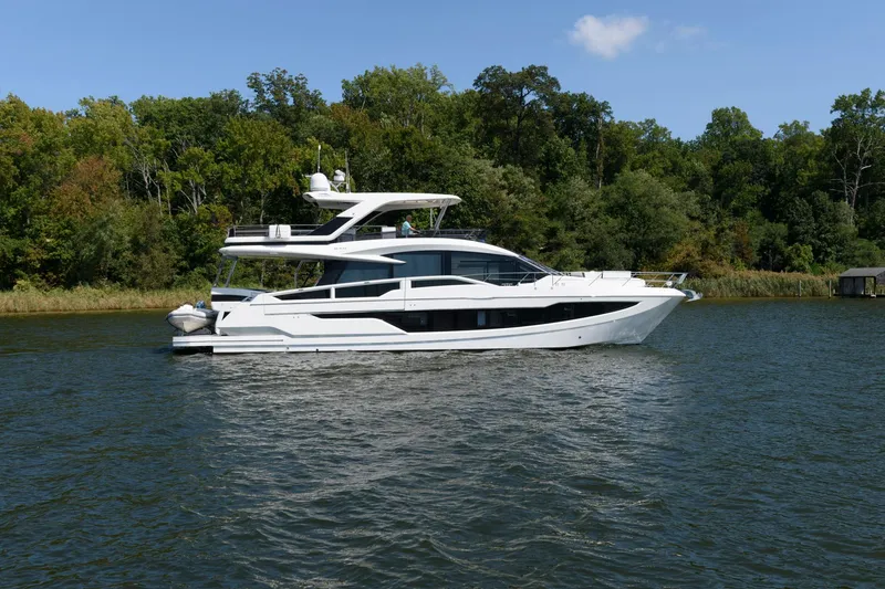 Slide: The Image of 2018 Galeon 640 Fly yacht cruising on a serene lake with lush green trees. - 7