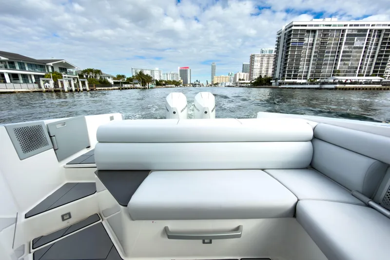 Slide: The Image of 2022 Aviara AV32 OB boat with luxurious seating, cruising near waterfront buildings. - 26