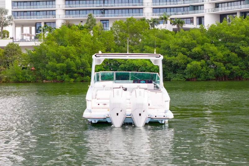Slide: The Image of 2022 Aviara AV32 OB boat on water, with modern building and greenery in background. - 3