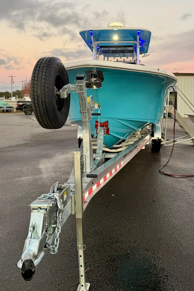 Slide: The Image of 2025 Key West 291 FS boat on trailer, vibrant blue hull, parked outdoors. - 12