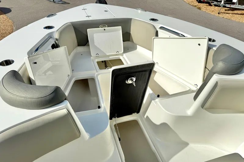 Slide: The Image of 2025 Key West 291 FS boat interior with seating and logo, under a partly cloudy sky. - 17