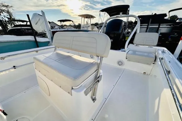 Slide: The Image of 2025 Boston Whaler 190 Montauk boat interior with seating and console, under a bright sky. - 10