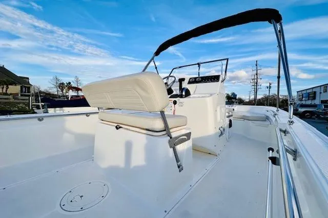 Slide: The Image of 2025 Boston Whaler 190 Montauk boat interior with seating and console under blue sky. - 16