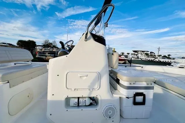 Slide: The Image of 2025 Boston Whaler 190 Montauk boat interior with console and seating, under a clear blue sky. - 18
