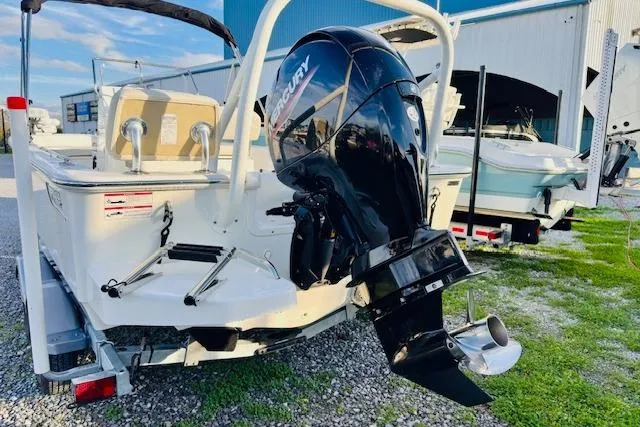 Slide: The Image of 2025 Boston Whaler 190 Montauk boat with Mercury outboard motor, parked outdoors. - 2