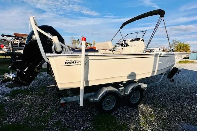 Slide: The Image of 2025 Boston Whaler 190 Montauk boat on trailer, parked outdoors under blue sky. - 4