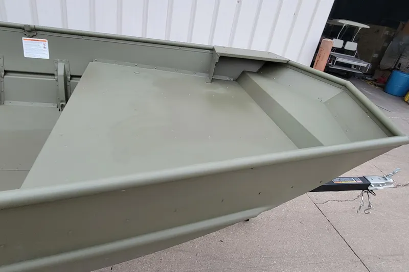 Slide: The Image of 2025 Lowe L1648M Aura Jon boat, olive green, parked on concrete near a building. - 11
