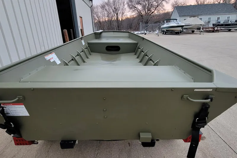 Slide: The Image of 2025 Lowe L1648M Aura Jon boat, green, parked outside a building. - 5