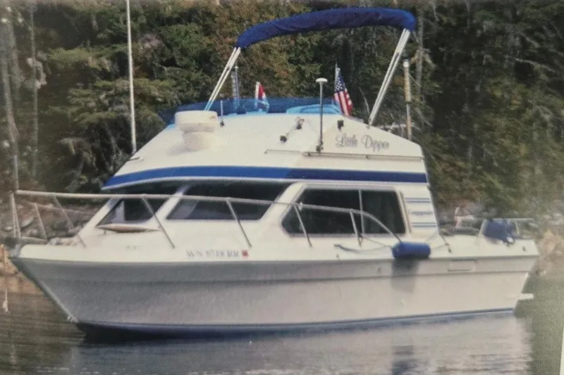The Image of 2001 Commander Flybridge Sedan boat on calm water with forest backdrop. - 0