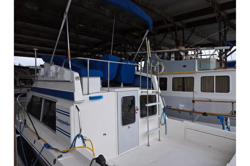 Slide: The Image of 2001 Commander Flybridge Sedan boat docked in a covered marina. - 11