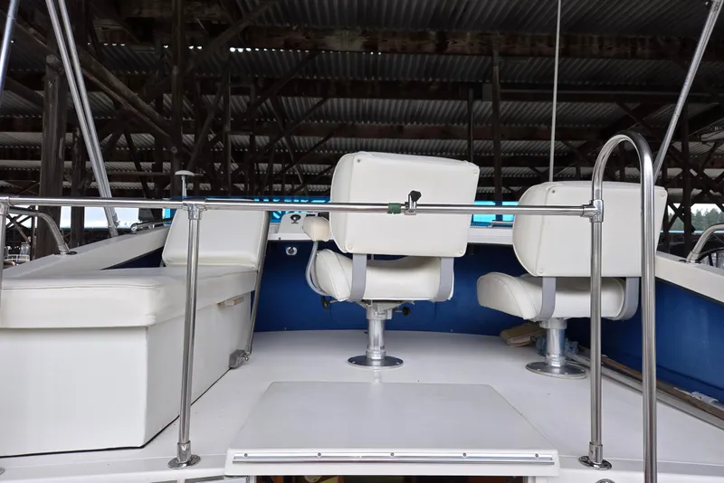Slide: The Image of 2001 Commander Flybridge Sedan boat interior with white seating and metal railings. - 13