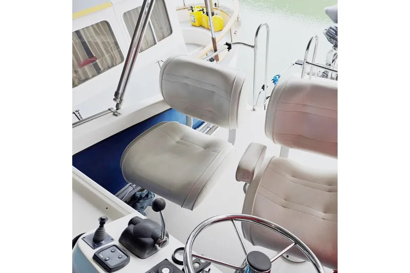 Slide: The Image of 2001 Commander Flybridge Sedan helm with dual seats and steering wheel. - 15