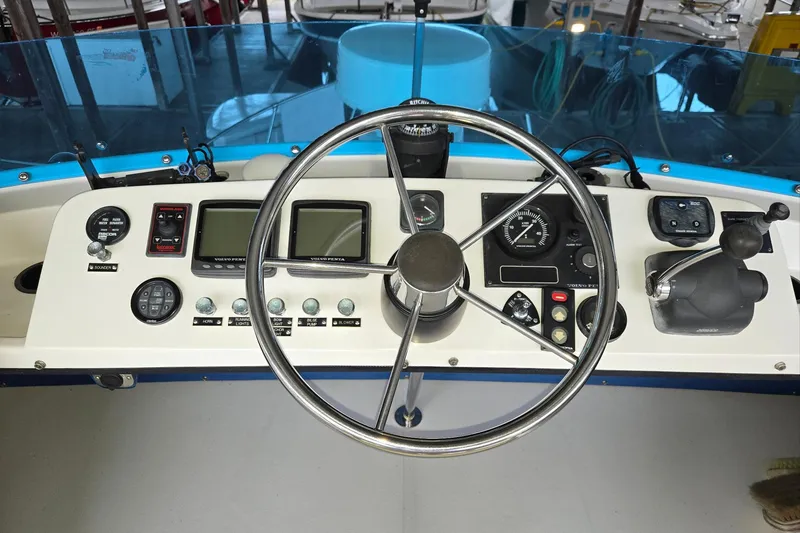 Slide: The Image of 2001 Commander Flybridge Sedan helm with steering wheel and navigation controls. - 17
