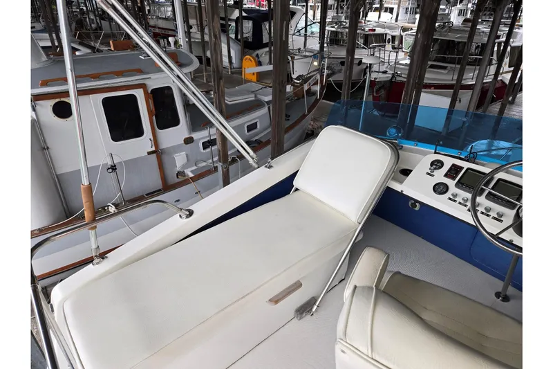 Slide: The Image of 2001 Commander Flybridge Sedan interior with helm and seating, docked among other boats. - 22