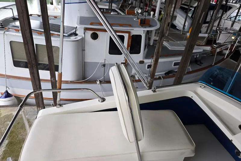 Slide: The Image of 2001 Commander Flybridge Sedan interior with docked boats in marina background. - 24