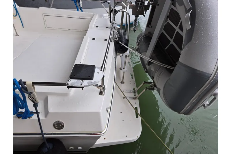 Slide: The Image of 2001 Commander Flybridge Sedan boat with attached inflatable dinghy on water. - 28